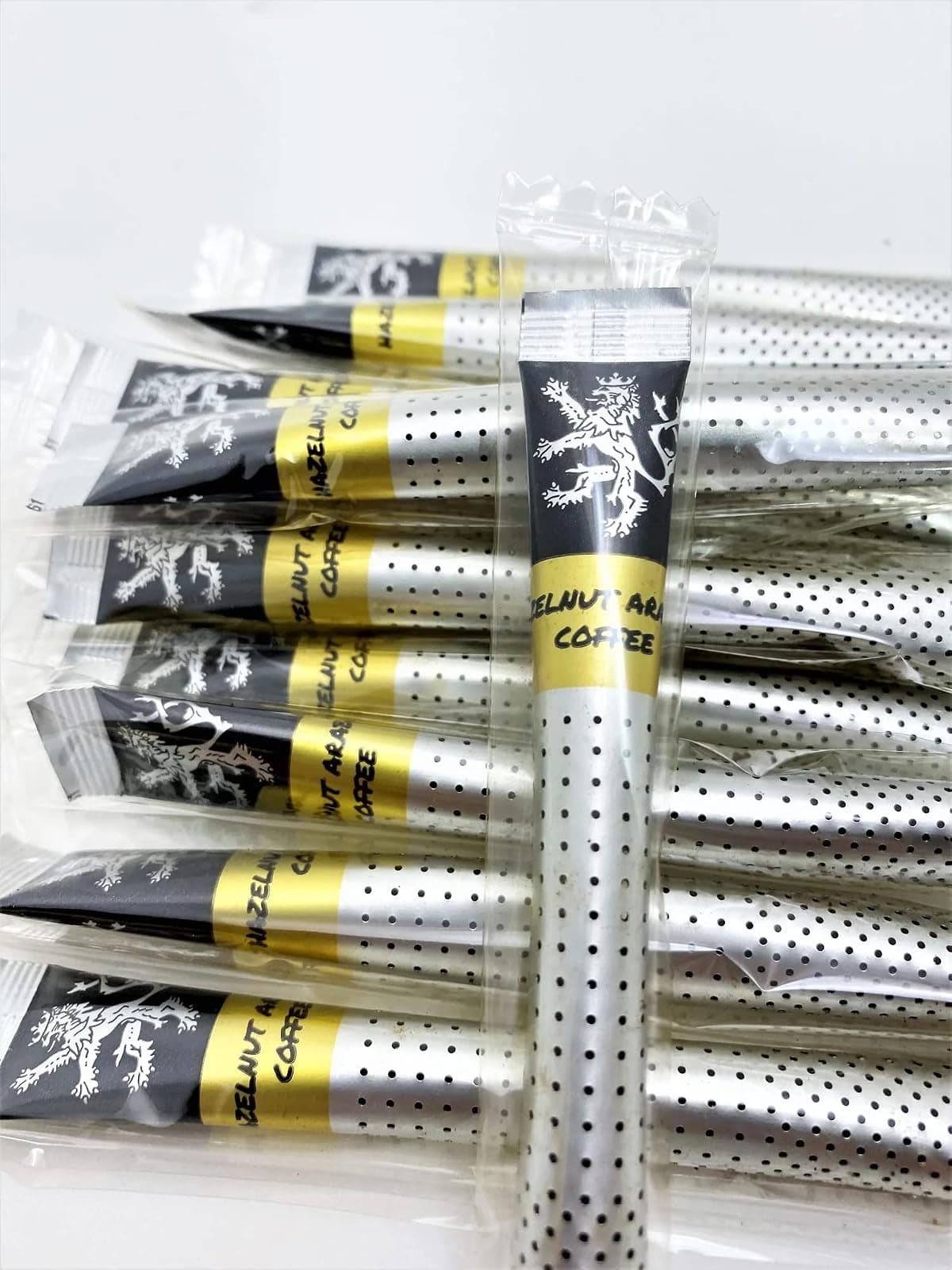 Hazelnut Arabica Coffee sticks in their individual wrappers on a plain background